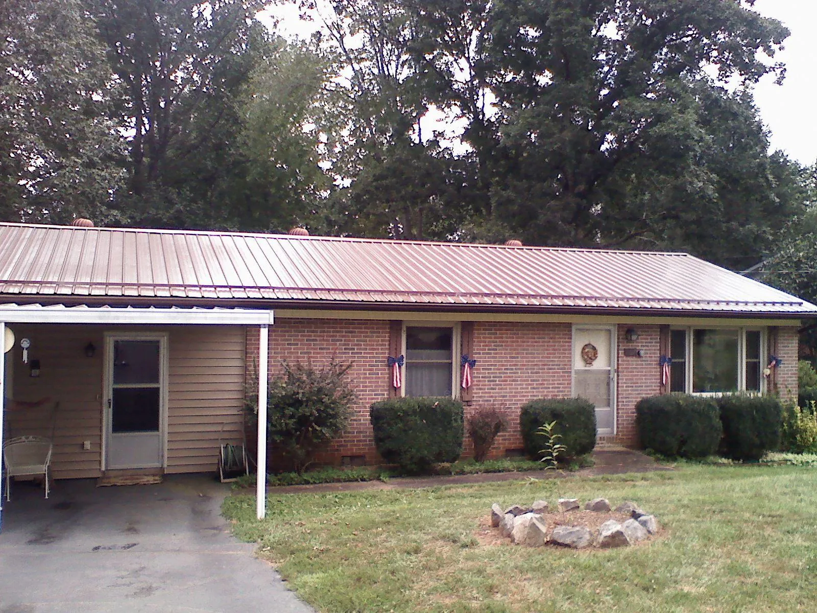 Bronze metal roof and carport on a brick ranch home — Roof Repair work by our crew in Chunchula