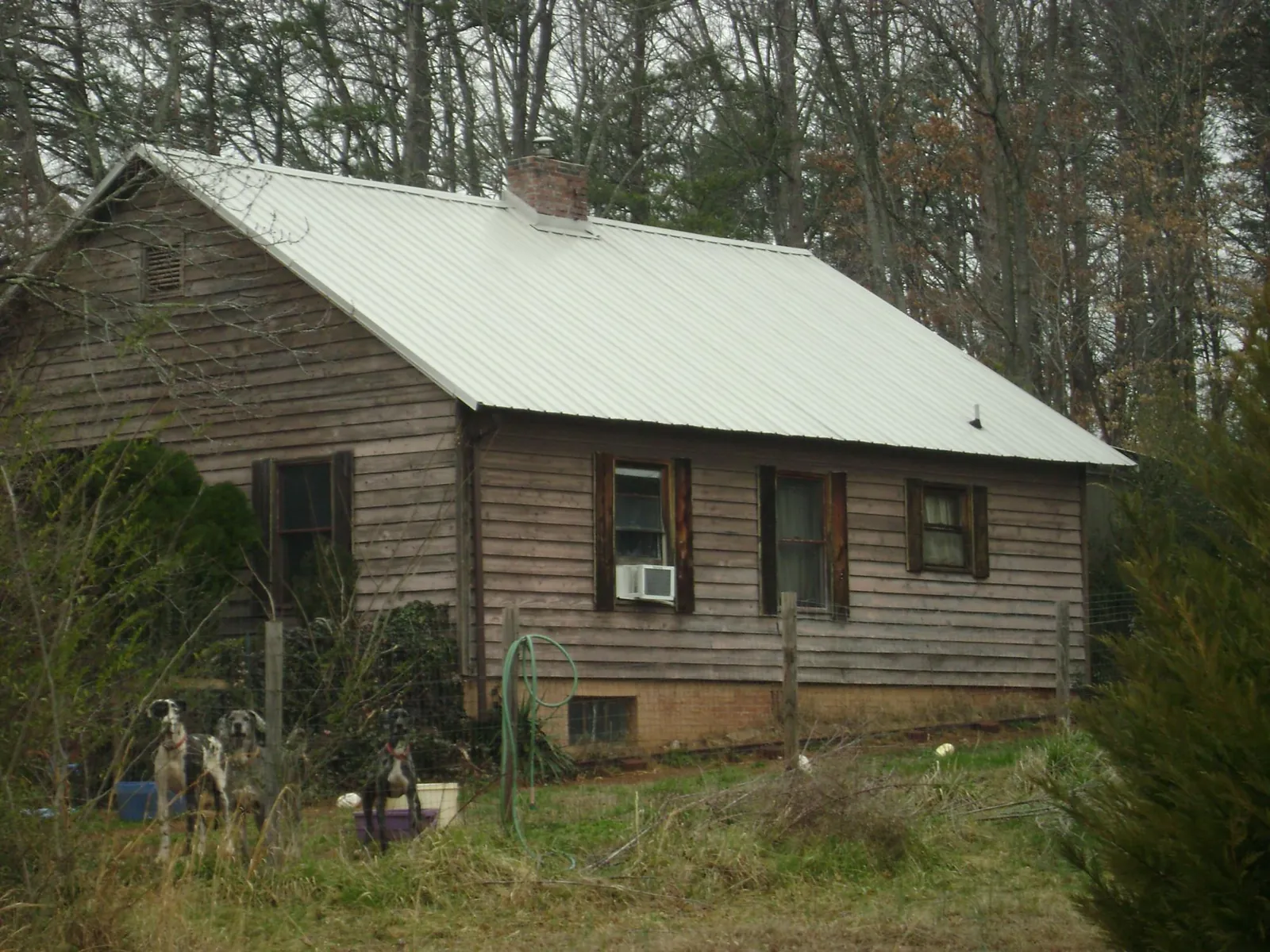White metal roof on an old wood sided farmhouse, from a Metal Roof Installation job in Chunchula